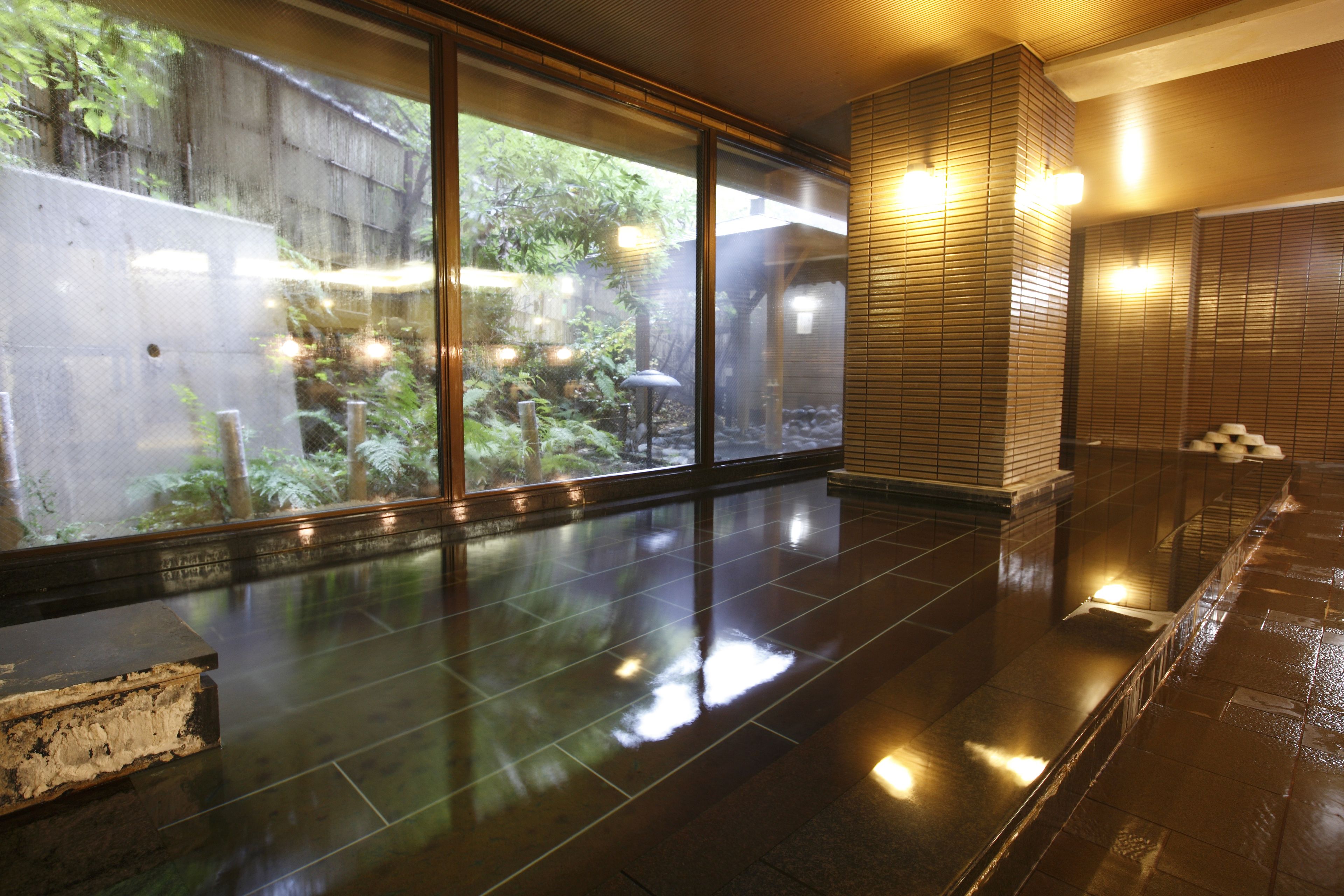 A spacious indoor area with a polished floor, large windows, and a wooden wall structure.