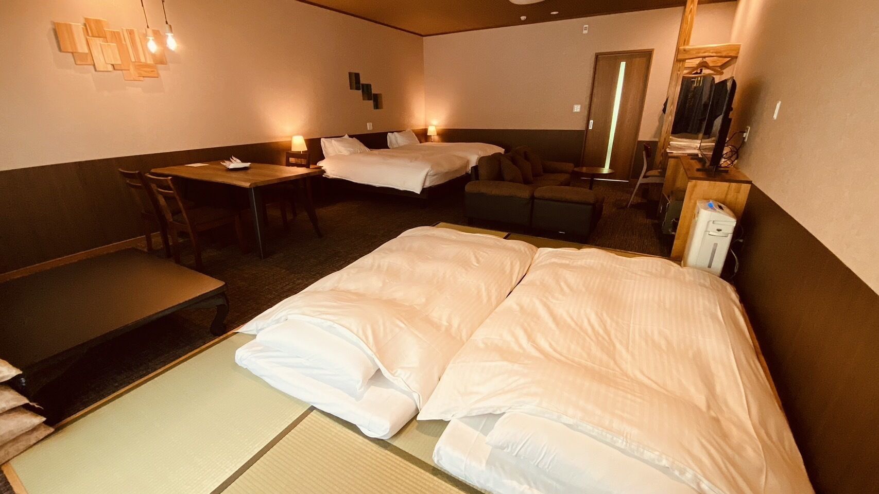 Una habitación de hotel con cama, sofá, una mesita y un banco.