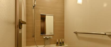 Ein Badezimmer mit Dusche, Spiegel, Handtuchhalter und Waschbecken mit Seifenspendern.