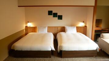 Een hotelkamer met twee bedden, houten hoofdeinden en bedlampjes.