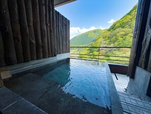 A hot tub with a view of a mountainous landscape. - Yuze Hotel (Kazuno)