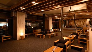 Un espace salon chaleureux et bien éclairé, doté de meubles en bois et d’un foyer central.