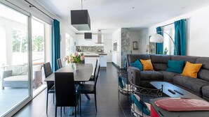A modern living room with a sofa, coffee table, and dining area. - Villa in Vidauban near Sainte Maxime Beach (Vidauban)