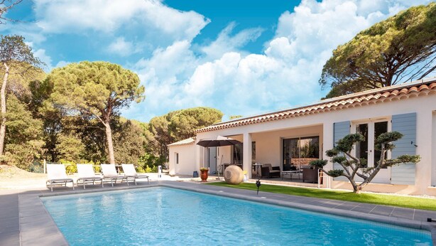 A swimming pool with lounge chairs, a patio area, and a building with a tiled roof. - Villa in Vidauban near Sainte Maxime Beach (Vidauban)