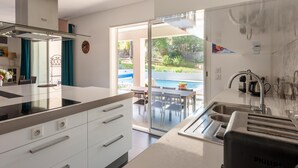 A modern kitchen with a glass door leading to a patio area. - Villa in Vidauban near Sainte Maxime Beach (Vidauban)