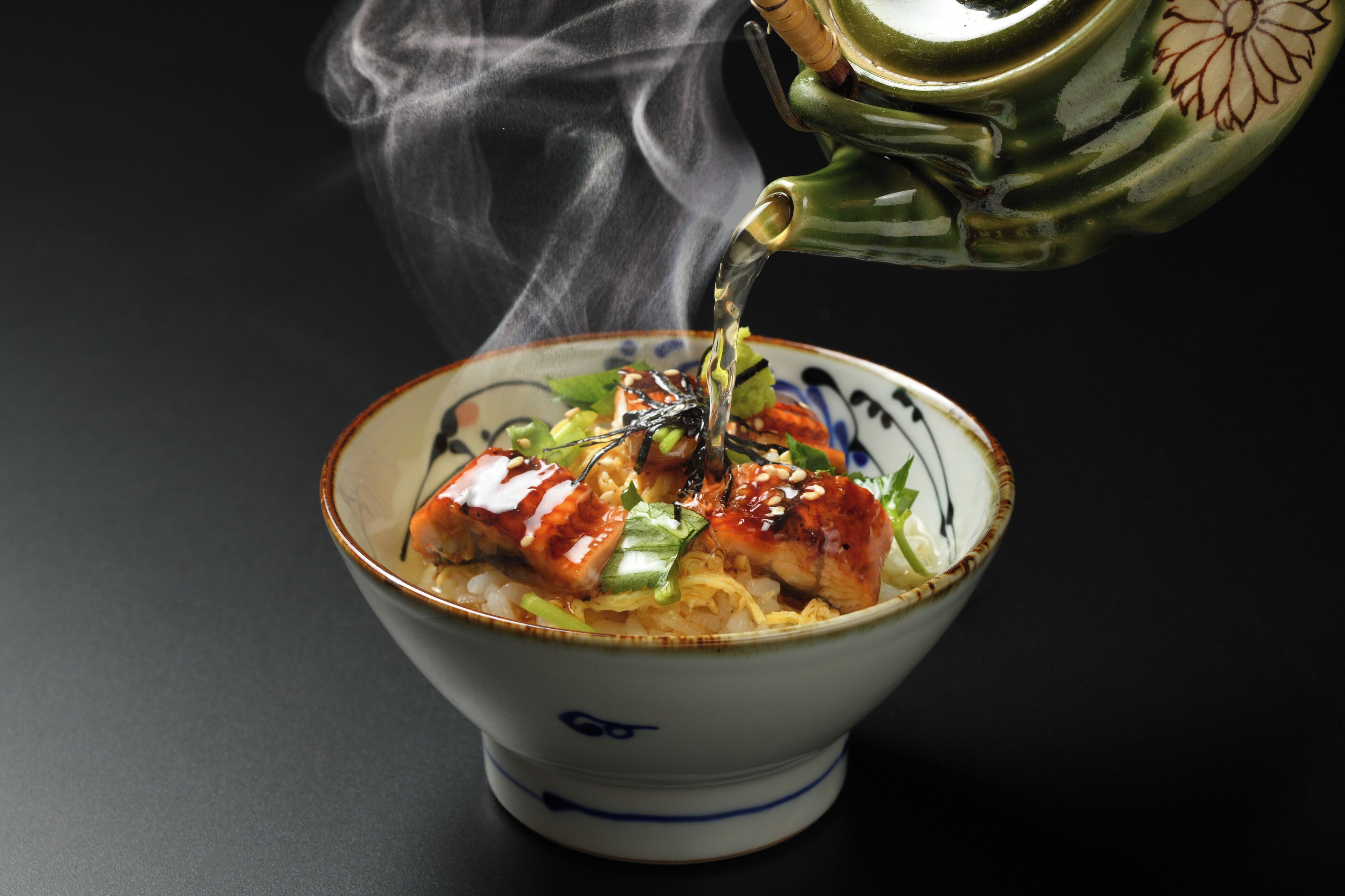 A bowl of ramen with a steaming hot pot on top.
