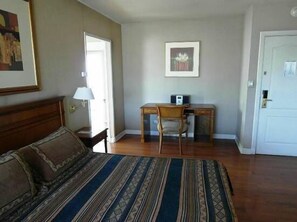 Un dormitorio con cama, escritorio y silla.