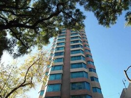 Um edifício alto e retangular com vários andares e janelas amplas.