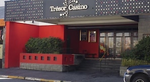 Um edifício com fachada vermelha e uma placa com a inscrição 'Tresor Casino'.