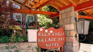 A wooden sign for Ruca Cheli Village Ski Hotel with a stone wall and a lantern. - Ruca Cheli Village Ski Hotel (San Carlos de Bariloche)