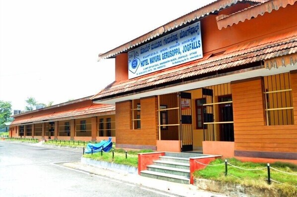 A hotel building with a signboard, a covered entrance, and a staircase leading to the entrance. - KSTDC Hotel Mayura Gerusoppa (Sagara)