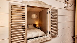 A cozy room with a bed, a small bedside table, and a hanging light fixture. - Holiday home suitable for families with sauna (Wilogne)
