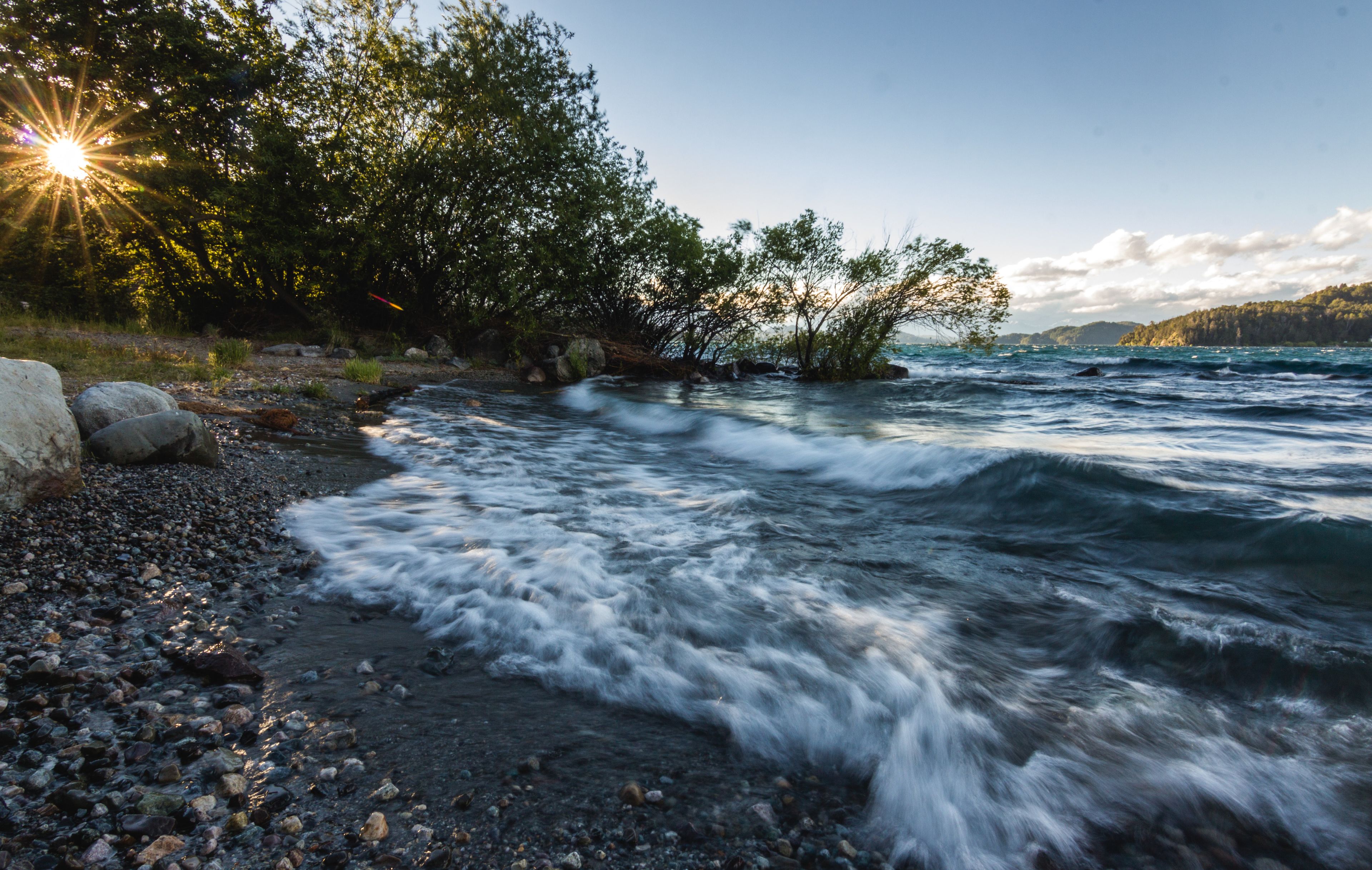 A river with a rocky shore and trees.