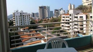 A balcony with a view of a cityscape, including high-rise buildings and a mountain in the distance. - Apartamento Mar Azul - Smr143a (Santa Marta)