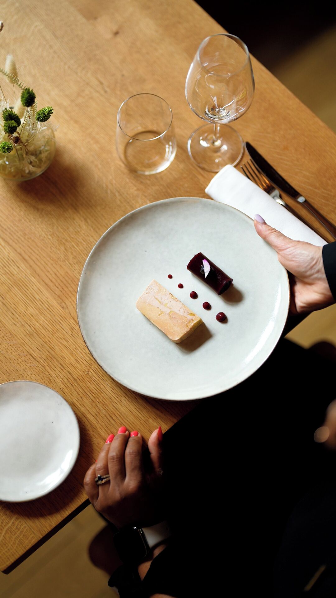 Une table à manger avec une assiette de nourriture, un verre à vin et un couteau.