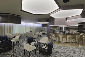 A hotel lobby with seating areas, a bar, and a reception desk. - bai Hotel Cebu (Mandaue)