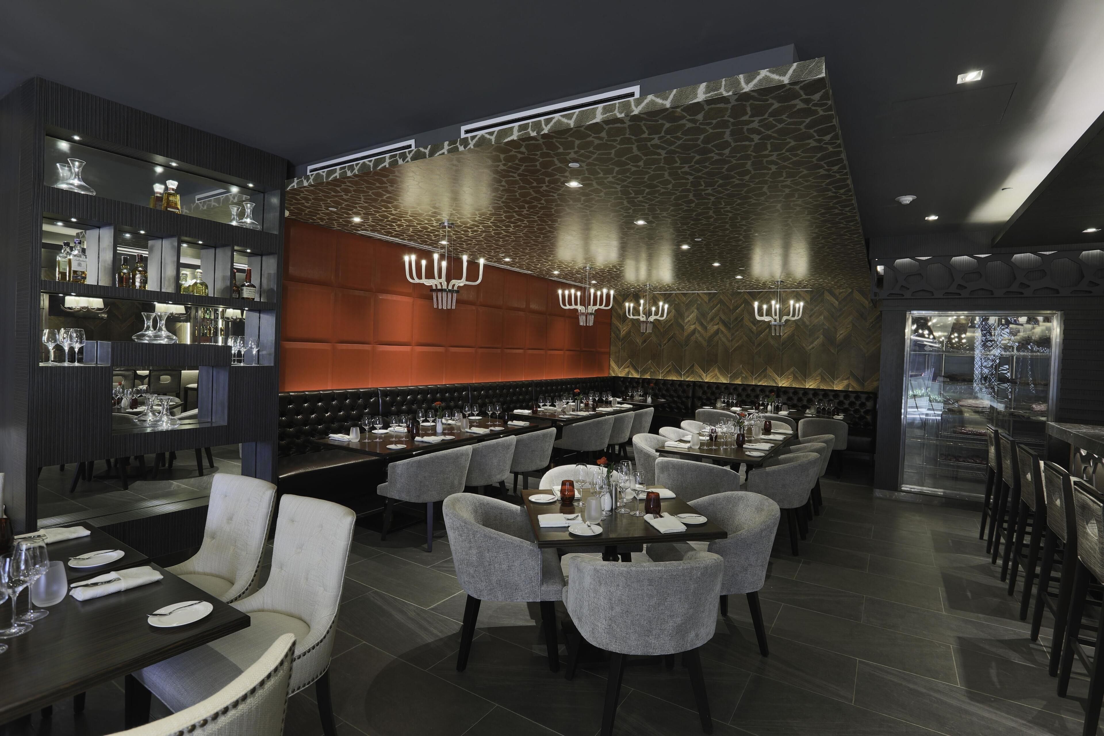 Ein modernes Restaurantambiente mit Bar, Sitzgelegenheiten und einer dekorativen Wand.