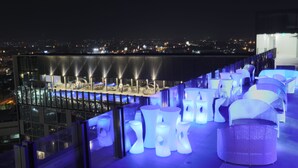 A rooftop bar with illuminated furniture and a city view at night. - bai Hotel Cebu (Mandaue)