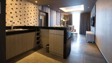 Una cocina moderna con una isla central, una estantería para vinos empotrada y un pequeño cubo de basura.