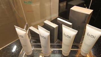 Presentación de artículos de baño del hotel bai, incluyendo loción, gel de ducha, acondicionador y champú.