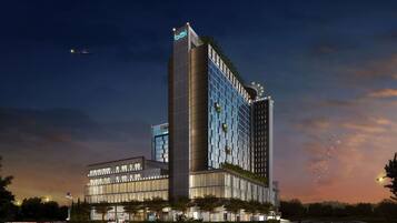 Een modern hotel met een opvallend verticaal ontwerp, grote ramen en een dakbostuin.