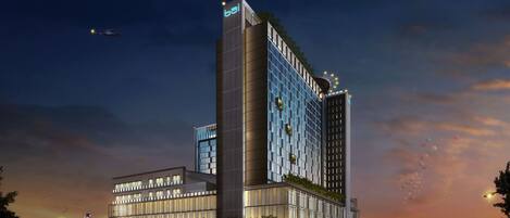 Un hotel moderno caratterizzato da un design verticale marcato, ampie finestre e un giardino sul tetto.
