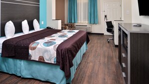 A hotel room with a large bed, a desk, and a TV. - Americas Best Value Inn & Suites Spring Houston N (Spring)