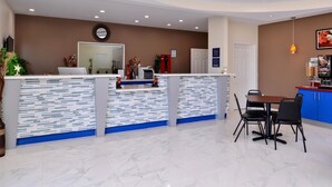 A modern reception area with a counter, seating, and a coffee machine. - Americas Best Value Inn & Suites Spring Houston N (Spring)
