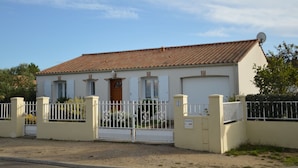 A single-story building with a tiled roof, a gated entrance, and a satellite dish on the roof. - Quiet holiday home by the sea in the Loire (Talmont-St. Hilaire)