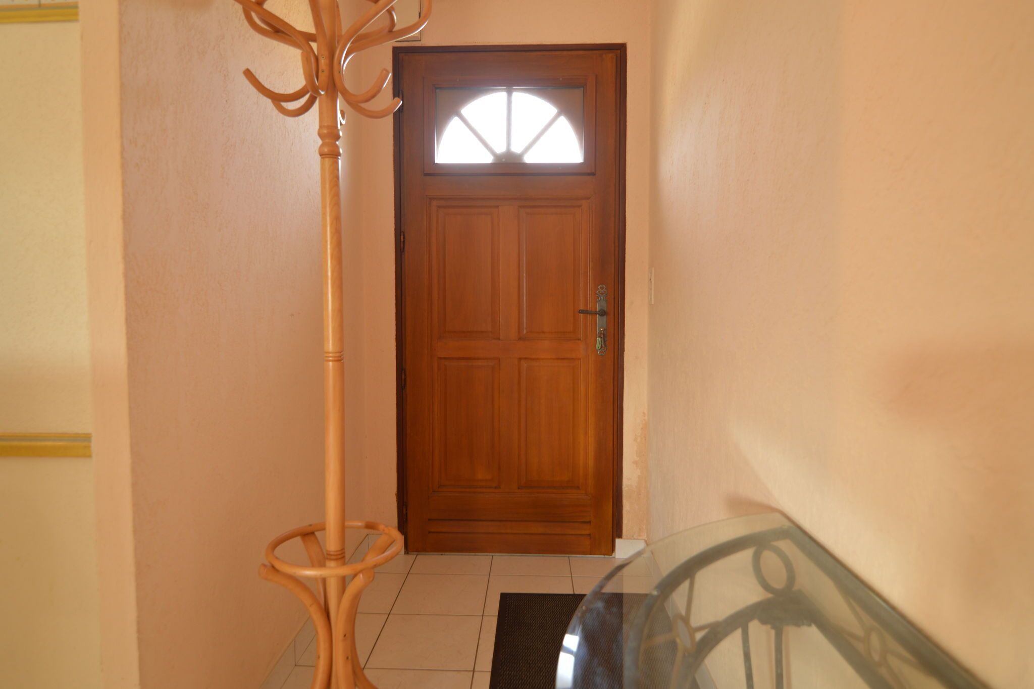 Una puerta de madera con un panel de vidrio y un picaporte.