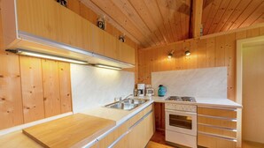 A modern kitchen with wooden cabinets, stainless steel appliances, and a wooden countertop.