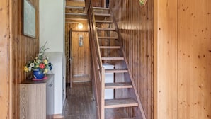 A wooden interior with a staircase leading to a second floor.