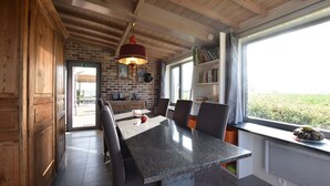 Una cucina moderna con un piano di lavoro in granito, mobili in legno e una parete in mattoni.