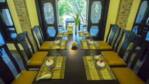 A dining table set for a meal with chairs, a central bowl, and teacups. - Hue Ecolodge (Hue)