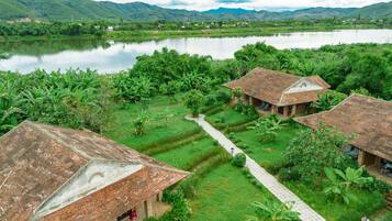 A rural setting with traditional houses, a clear path, and a lake.