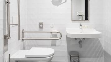 A modern bathroom with a white toilet, a sink, and a mirror.