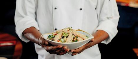 Un chef sostiene un bol de comida.