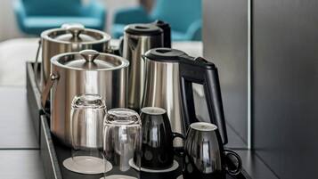 Ein Tablett mit verschiedenen Küchenutensilien, darunter eine Kaffeemaschine, Töpfe und Gläser.