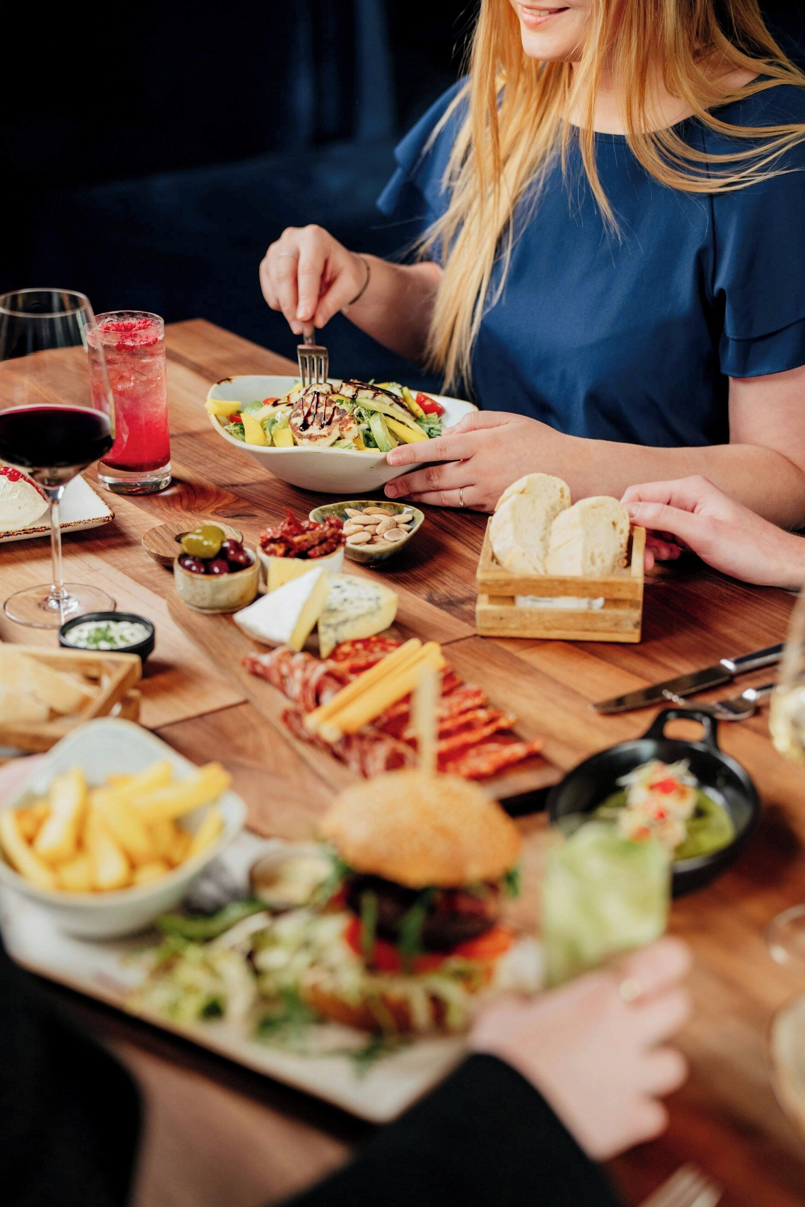 Una mesa de comedor con diferentes alimentos y una bebida.