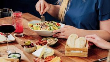 Una mesa de comedor con diferentes alimentos y una bebida.