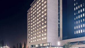 A modern hotel with a reflective pool in front, large windows, and a prominent "Courtyard" sign. - Courtyard by Marriott Brno (Brno)
