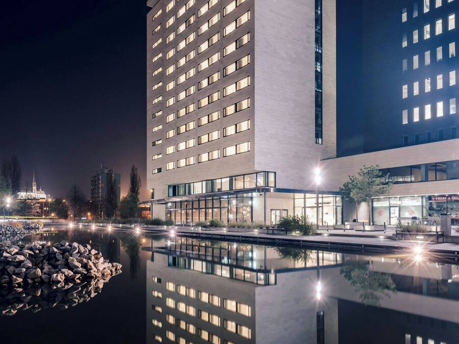 A modern hotel with a reflective pool in front, large windows, and a prominent "Courtyard" sign.