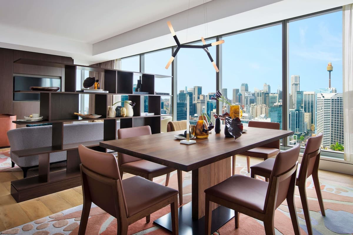 A modern dining area with a city view, a high ceiling, and a minimalist design.