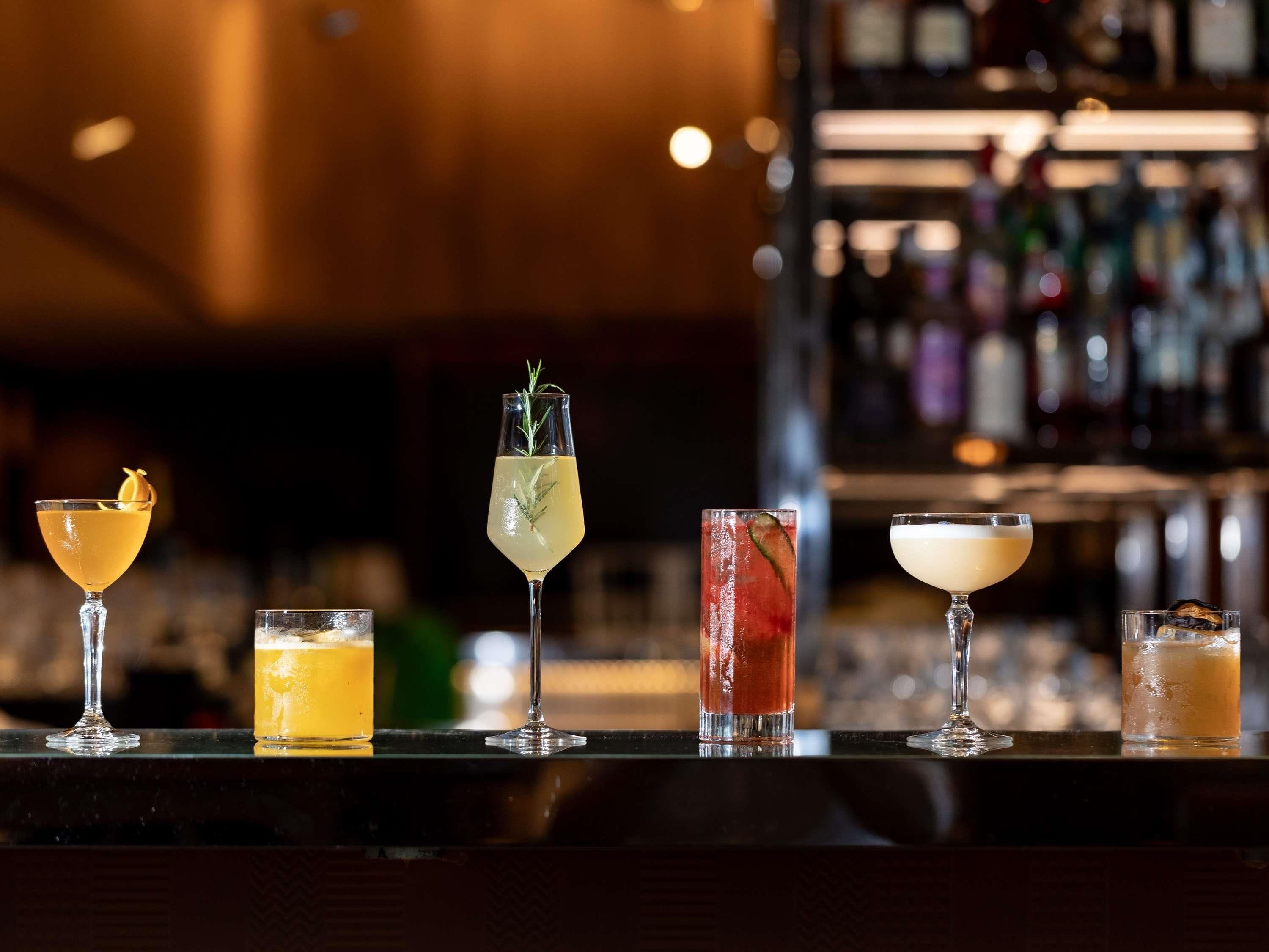 A bar counter with various cocktails.