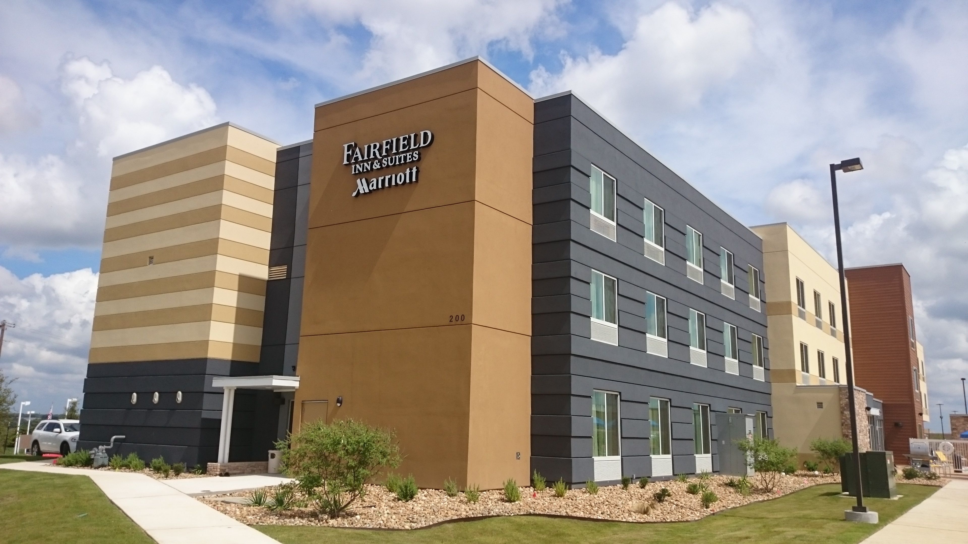 Een modern hotelgebouw met een bord waarop staat 'FAIRFIELD INN & SUITES Marriott'.