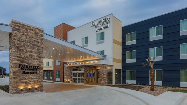 A Fairfield Inn & Suites Marriott hotel entrance with a stone pillar, glass canopy, and a modern building facade. - Fairfield Inn & Suites Cuero (Cuero)