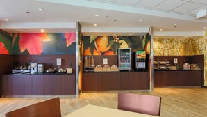 A modern cafe with wooden counters, a coffee machine, and a fruit display. - Fairfield Inn & Suites Cuero (Cuero)