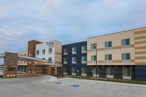 Un hotel de varios pisos con fachada moderna, incluyendo un letrero de Fairfield Inn & Suites by Marriott.