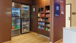 A corner market with refrigerated beverage dispensers and snack shelves. - Fairfield Inn & Suites Cuero (Cuero)