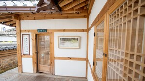 A traditional Japanese building with a wooden entrance, a signboard, and a framed picture on the wall. - Jiwoodang (Jeonju)